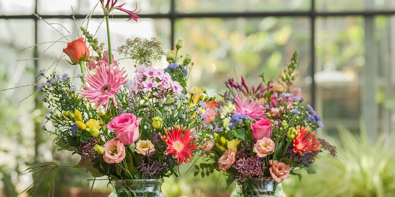 Twee grote kleurrijke en duurzame boeketten in een serre