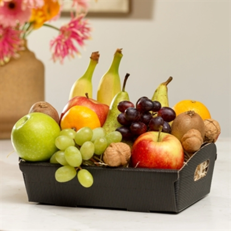 Fruitmand gevuld met verse appel, banaan, kiwi, sinaasappel, walnoot, druiven en banaan