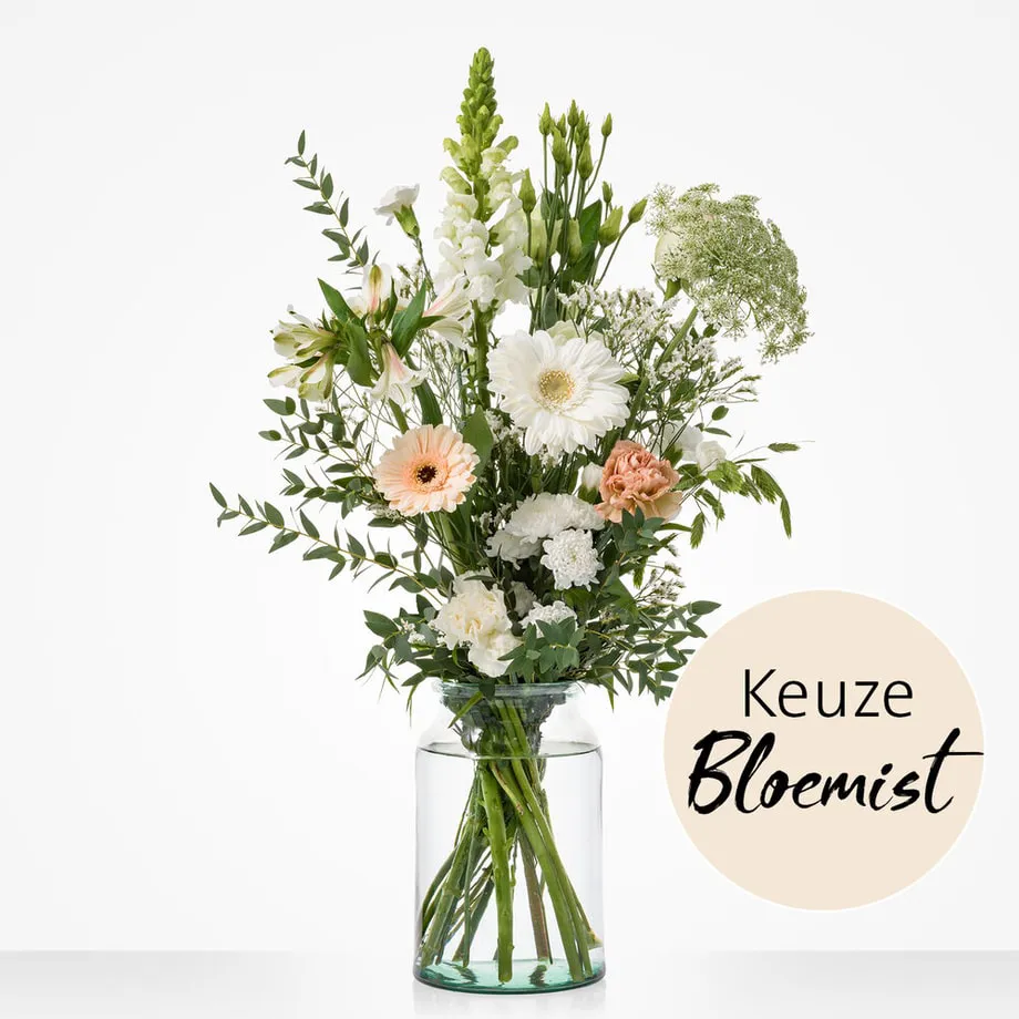 Luchtig wit veldboeket met subtiele perziktinten in glazen vaas