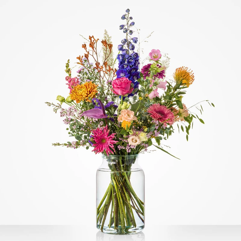 Boeket Deluxe in vaas met kleurrijke seizoensbloemen, gerbera's, rozen en delphinium
