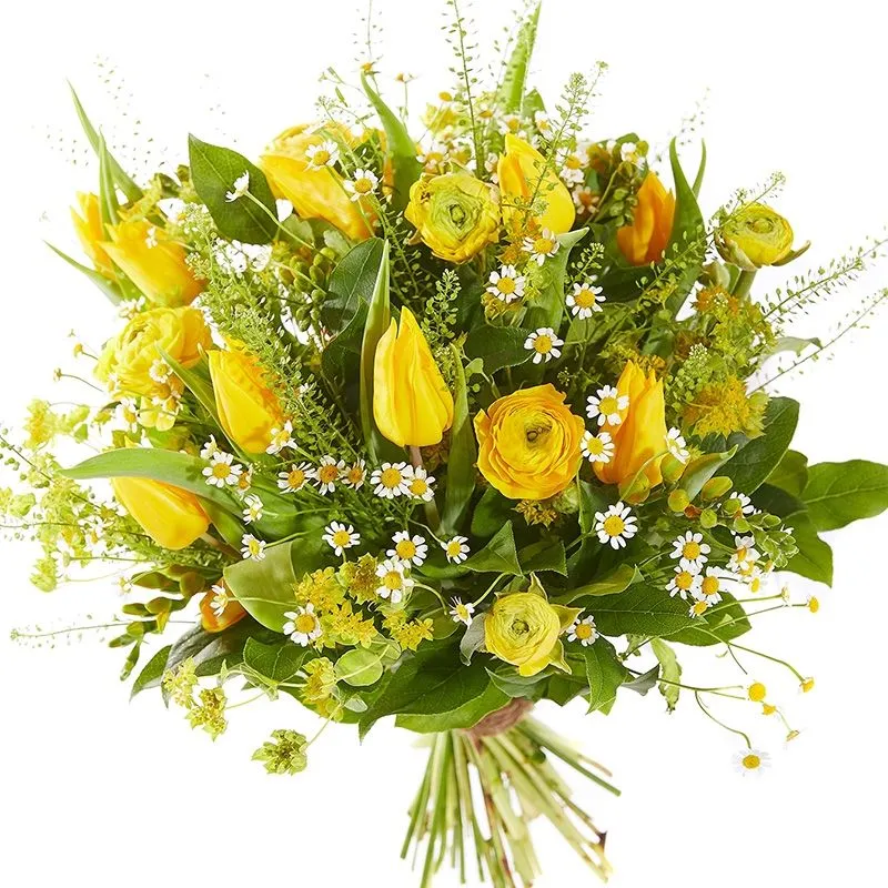 Fris voorjaarsboeket met gele tulpen, ranonkels en fijne kamillebloemen, speels gecombineerd met groen blad en seizoensbloemen