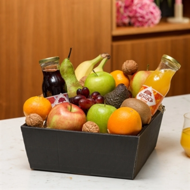 Luxe fruitmand met veel fruit, noten en twee flessen sap