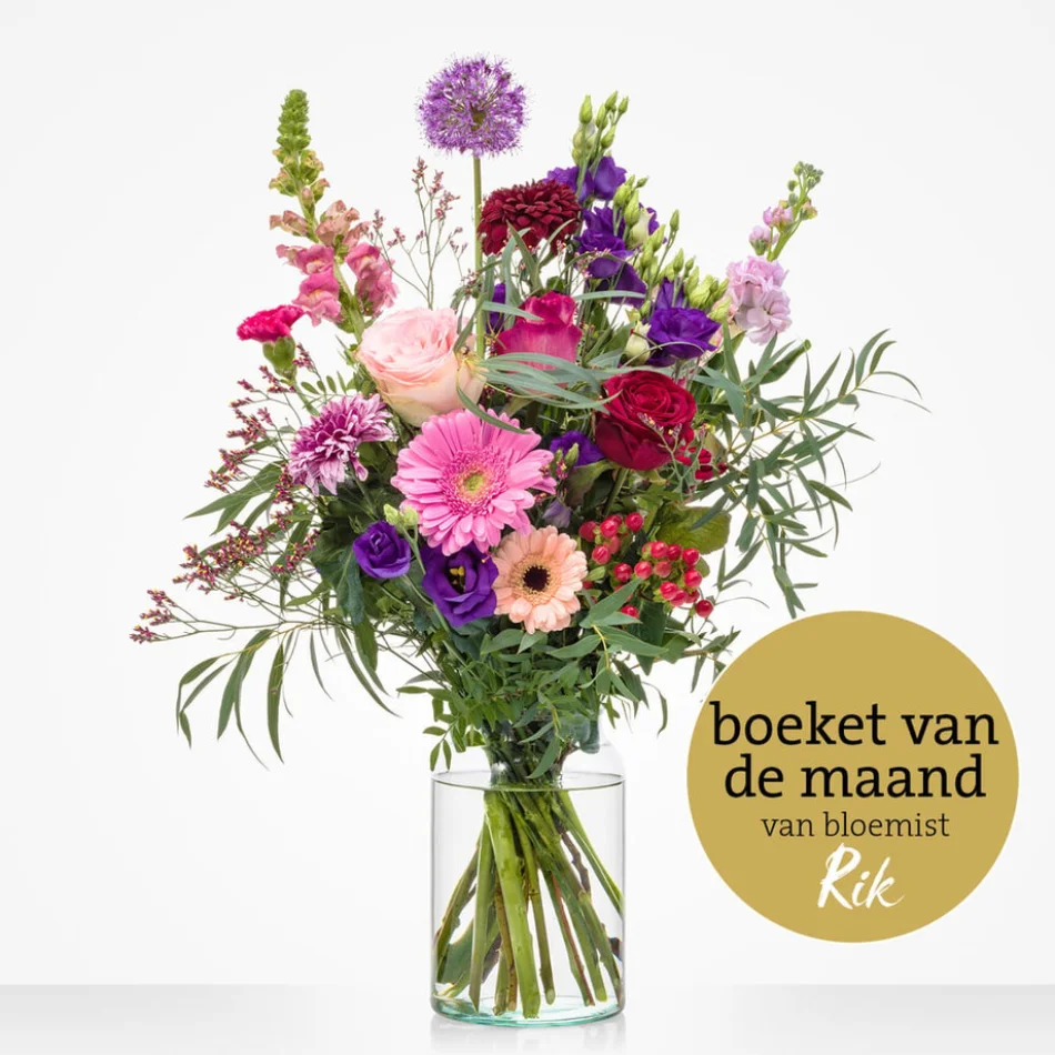Maandboeket mei met kleurrijke seizoensbloemen in glazen vaas