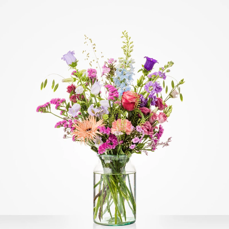 Boeket Zomergeluk in vaas met kleurrijke seizoensbloemen in roze, lila en lichtblauwe tinten 