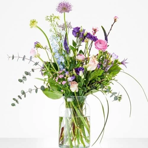 Luchtig voorjaarsboeket met ranonkels, lisianthus en veldbloemen in zachte pasteltinten