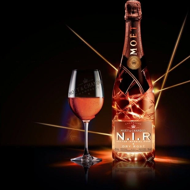 Moët & Chandon N.I.R. Nectar Impérial Rosé Dry 75CL met gevuld Moët & Chandon champagneglas tegen een donkere achtergrond
