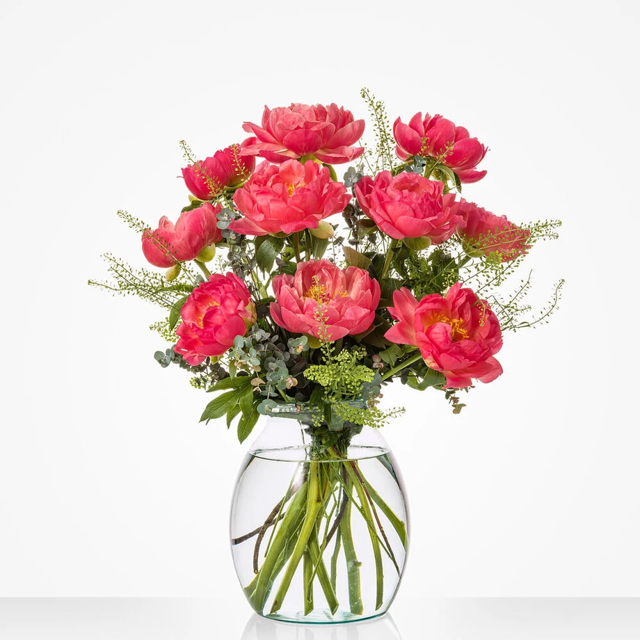 Glazen vaas met roze pioenrozen